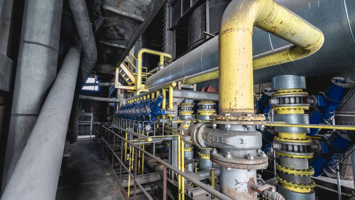 Insulated process pipework, flanged valves and access walkways on a live plant
